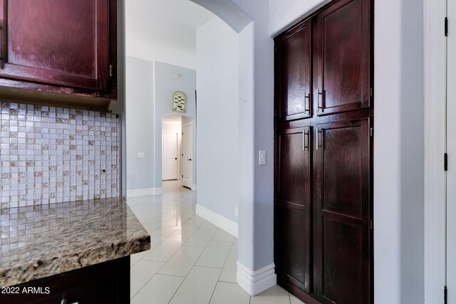 kitchen with decorative backsplash, vaulted ceiling, appliances with stainless steel finishes, sink, and light tile patterned flooring