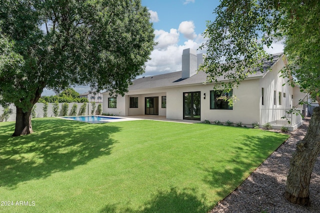 back of house featuring a fenced in pool, a patio area, and a yard