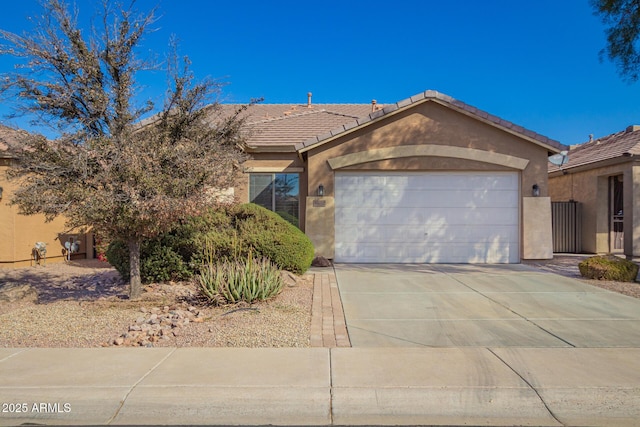 single story home with driveway, an attached garage, a tile roof, and stucco siding