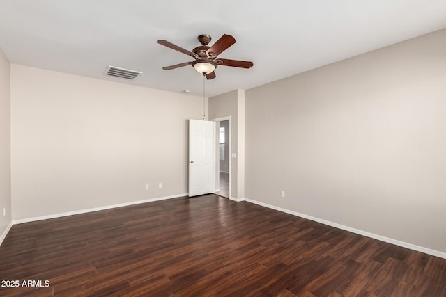 empty room featuring visible vents, dark wood finished floors, baseboards, and ceiling fan