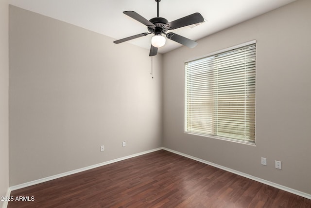 unfurnished room featuring dark wood-style floors, ceiling fan, and baseboards