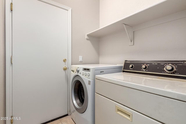 laundry room with light tile patterned floors, laundry area, and washing machine and clothes dryer