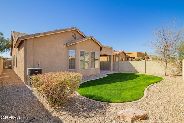 rear view of house with a patio area, a fenced backyard, central AC unit, and stucco siding