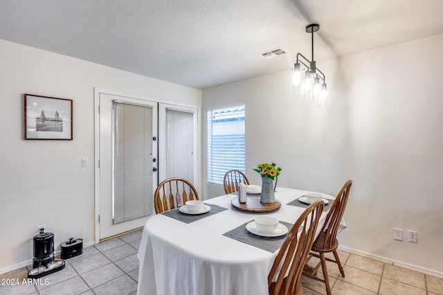 dining area with light tile patterned flooring and a chandelier