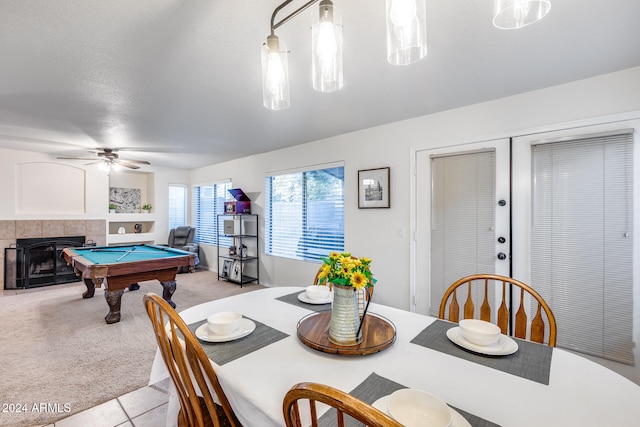 dining space featuring pool table, light colored carpet, a textured ceiling, ceiling fan, and a fireplace