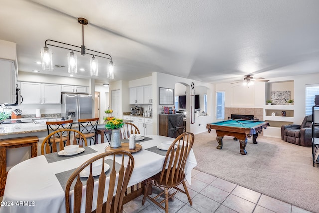 tiled dining room featuring ceiling fan, a textured ceiling, a tile fireplace, and billiards