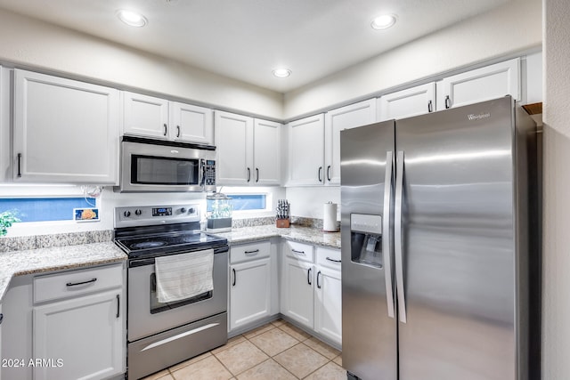 kitchen featuring white cabinetry, appliances with stainless steel finishes, and light tile patterned flooring