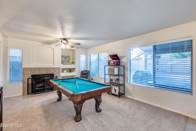 game room featuring light carpet, ceiling fan, a textured ceiling, a fireplace, and billiards