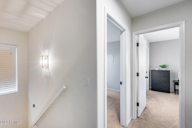 hallway featuring light colored carpet