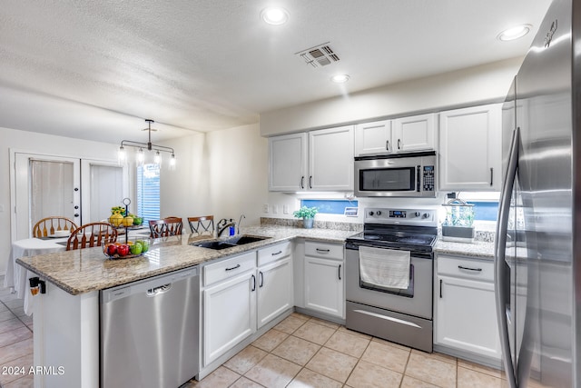 kitchen featuring white cabinets, kitchen peninsula, appliances with stainless steel finishes, and sink