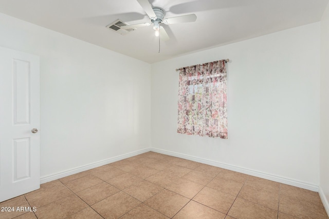 tiled spare room featuring ceiling fan