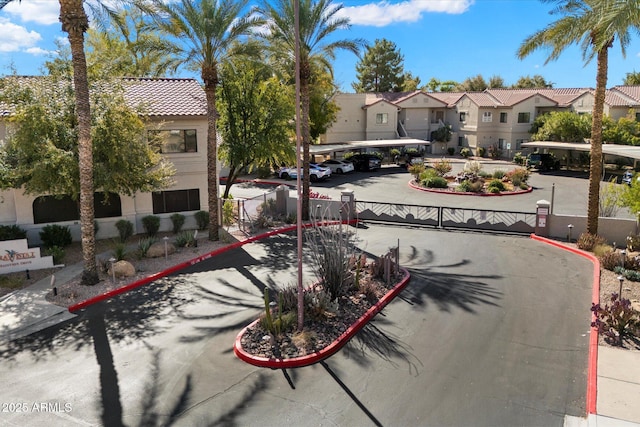 view of road featuring a gated entry, a residential view, a gate, and curbs