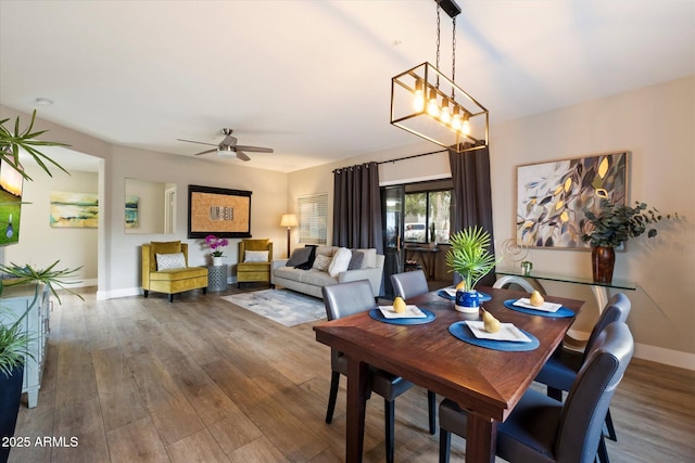 dining space with ceiling fan, wood finished floors, and baseboards