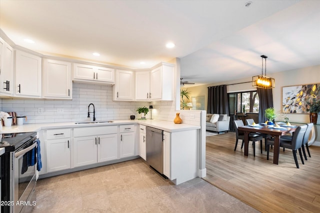 kitchen with decorative backsplash, appliances with stainless steel finishes, light countertops, white cabinetry, and a sink