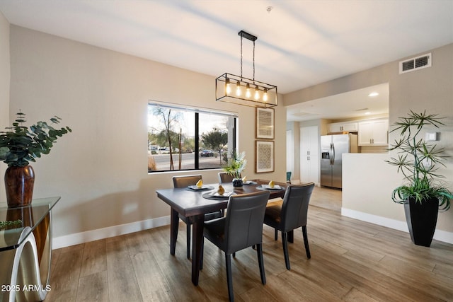 dining room with visible vents, baseboards, and wood finished floors