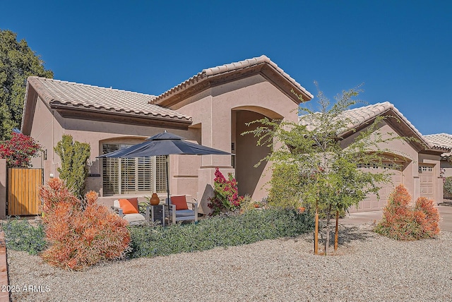 exterior space with stucco siding, a tile roof, and a garage