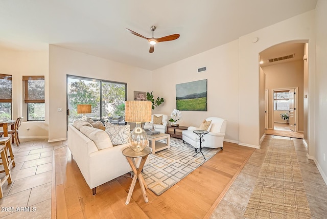 living room featuring a ceiling fan, visible vents, and light wood-type flooring