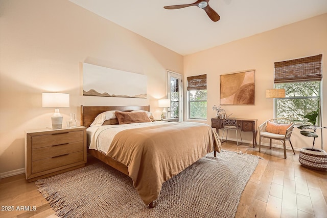 bedroom with ceiling fan, baseboards, and light wood-style flooring