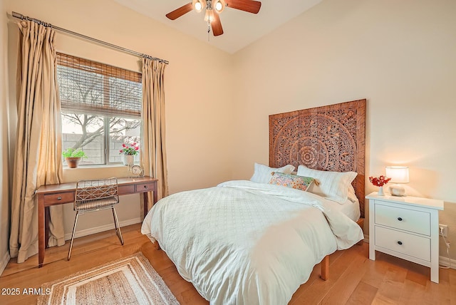 bedroom with baseboards, a ceiling fan, light wood-style floors, and vaulted ceiling