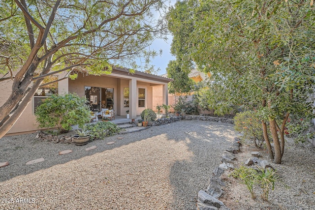 exterior space with stucco siding and fence