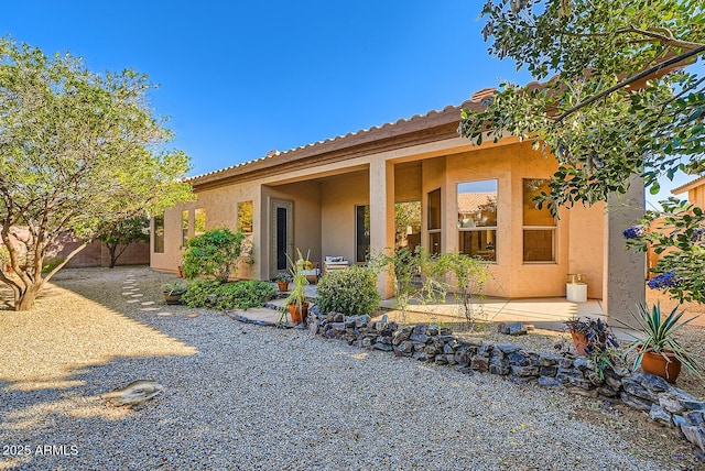 rear view of property with a patio area, stucco siding, and fence