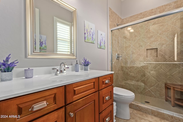 bathroom with toilet, vanity, tile patterned floors, and a shower with door