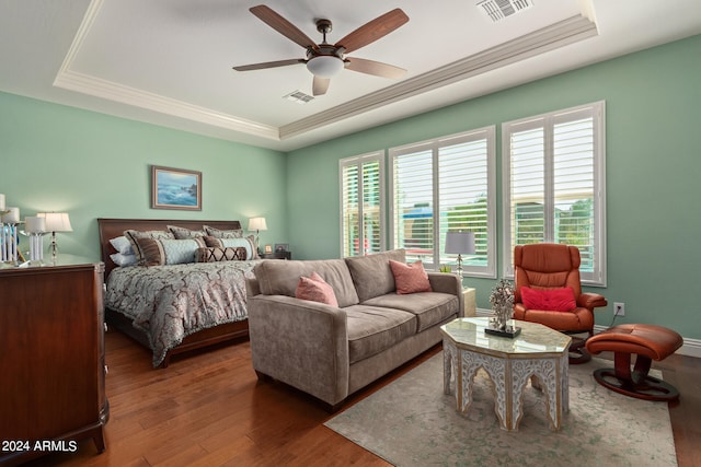 bedroom featuring ceiling fan, a tray ceiling, dark hardwood / wood-style flooring, and crown molding