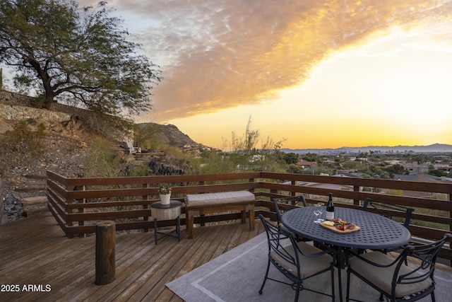 deck at dusk featuring a mountain view