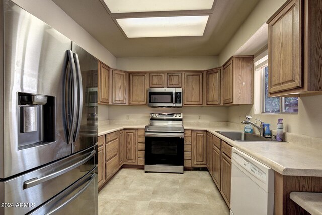 kitchen with sink, appliances with stainless steel finishes, and light tile patterned floors