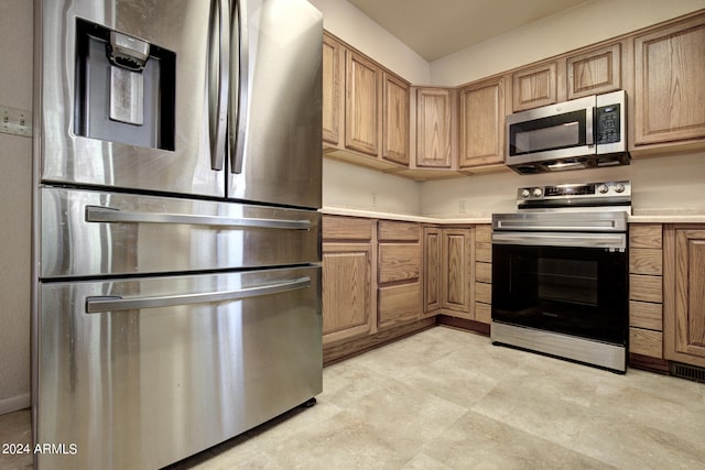 kitchen with light tile patterned flooring and stainless steel appliances