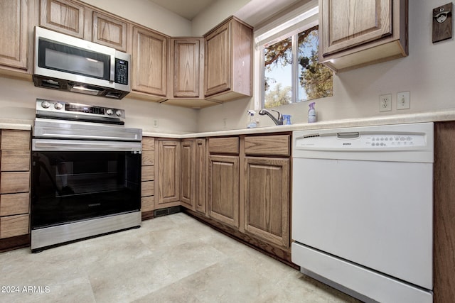 kitchen with sink, appliances with stainless steel finishes, and light tile patterned floors