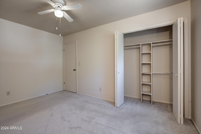 unfurnished bedroom featuring light carpet, a closet, and ceiling fan