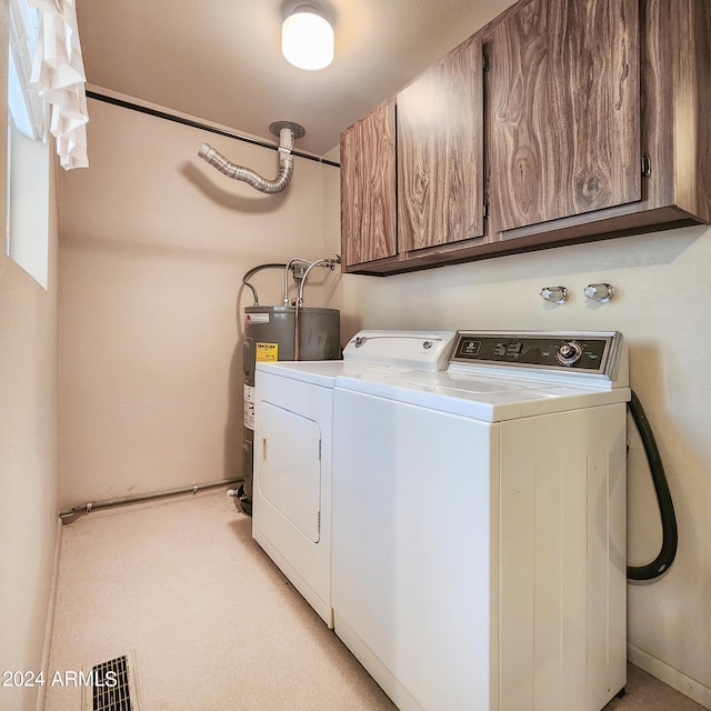 clothes washing area with washer and dryer, cabinets, and water heater