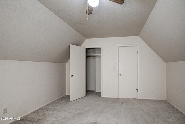 additional living space featuring carpet floors, a textured ceiling, ceiling fan, and vaulted ceiling