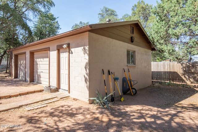 view of side of home featuring a garage and an outbuilding