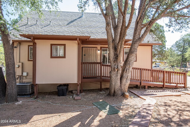 back of house with central air condition unit