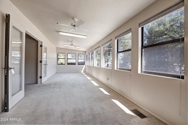 unfurnished sunroom featuring ceiling fan