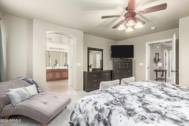 bedroom featuring connected bathroom, ceiling fan, and light carpet