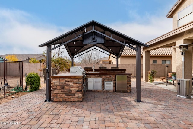 view of patio with a gazebo, area for grilling, and a grill