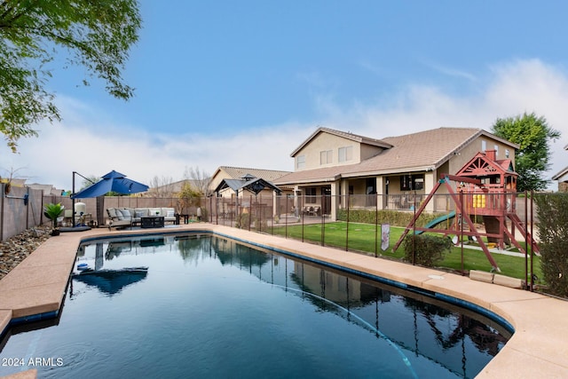 view of swimming pool featuring a playground and a yard