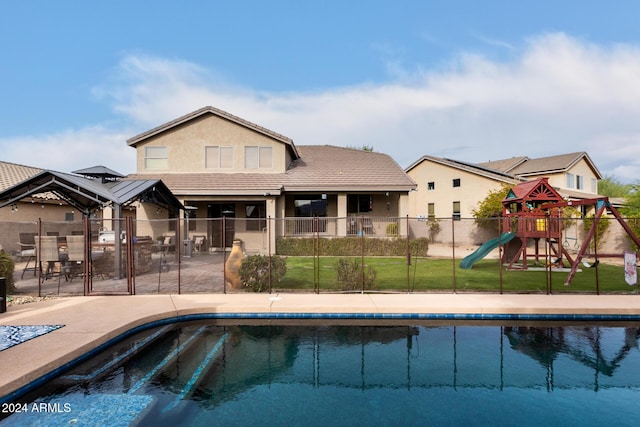 view of pool with a lawn and a playground