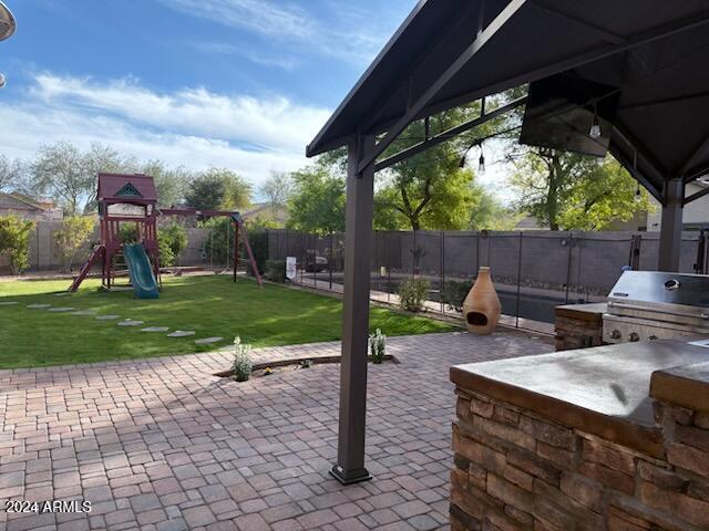 view of patio / terrace with a playground and area for grilling