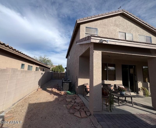 back of property featuring cooling unit and a patio