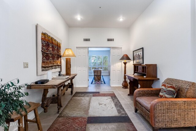 living area featuring a towering ceiling and light tile patterned floors