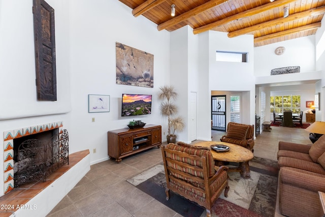 living room featuring beam ceiling, a towering ceiling, wooden ceiling, and light tile patterned floors