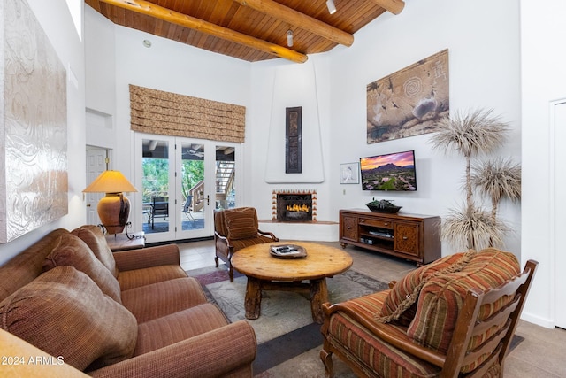 tiled living room featuring beam ceiling, french doors, a towering ceiling, a fireplace, and wood ceiling