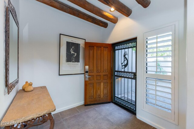 tiled entrance foyer with lofted ceiling with beams