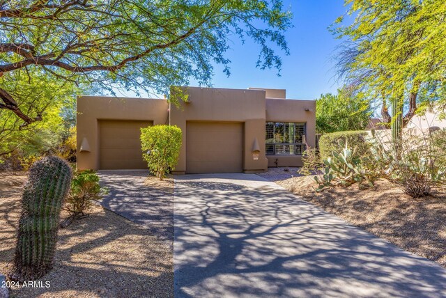 pueblo-style house featuring a garage