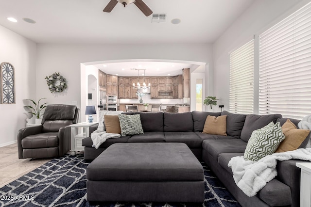 living room featuring arched walkways, a ceiling fan, recessed lighting, and baseboards