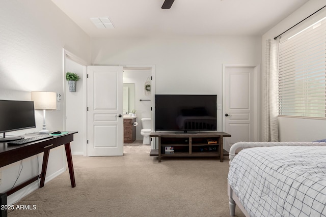 bedroom featuring light colored carpet, an office area, and connected bathroom